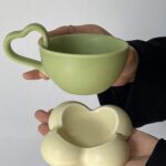 فنجان باللون الأخضر بيد شكل قلب